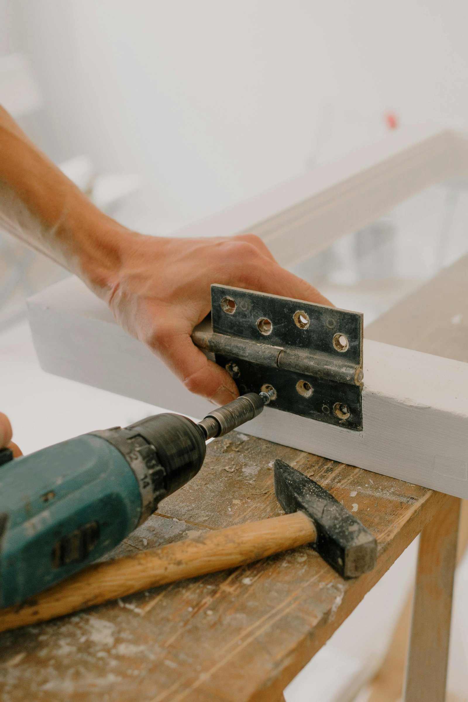 Handyman repairing a door hinge in Metro Vancouver